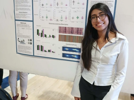 Undergraduate student standing next to their Poster Session Board