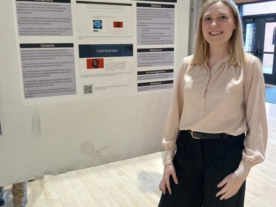 Undergraduate student standing next to their Poster Session Board
