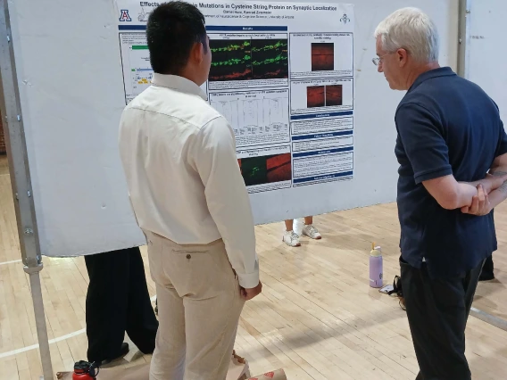 Undergraduate student standing next to their Poster Session Board