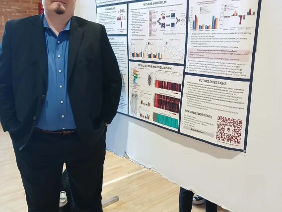 Undergraduate student standing next to their Poster Session Board