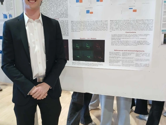 Undergraduate student standing next to their Poster Session Board