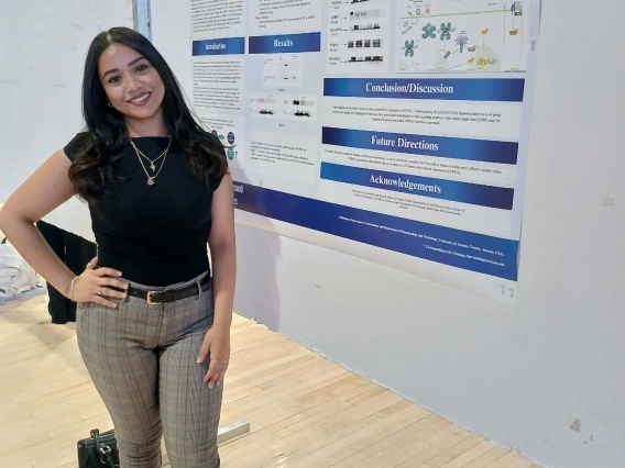 Undergraduate student standing next to their Poster Session Board