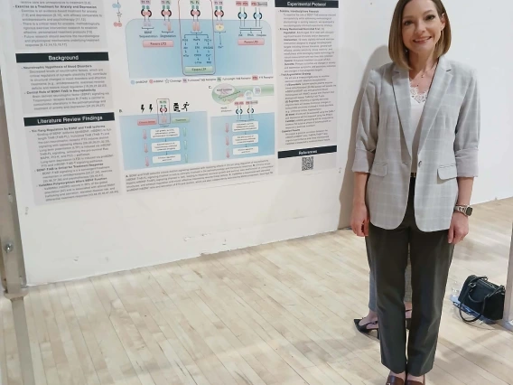 Undergraduate student standing next to their Poster Session Board