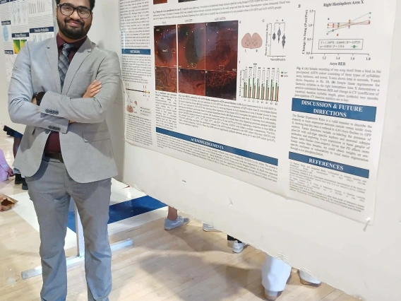 Undergraduate student standing next to their Poster Session Board