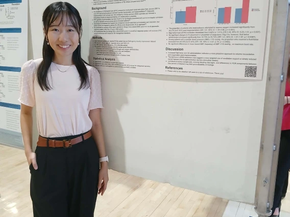 Undergraduate student standing next to their Poster Session Board