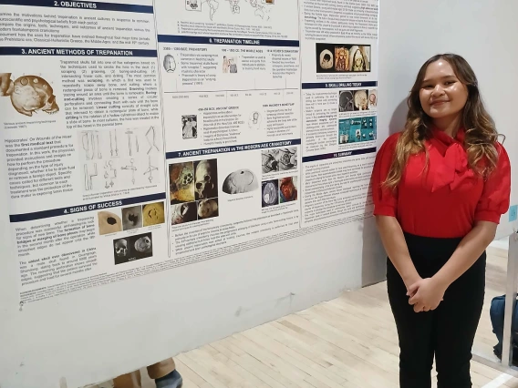 Undergraduate student standing next to their Poster Session Board