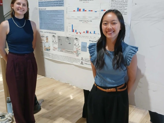 Undergraduate student standing next to their Poster Session Board
