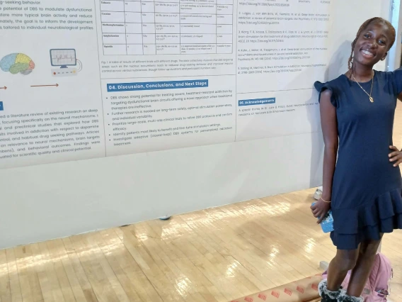 Undergraduate student standing next to their Poster Session Board