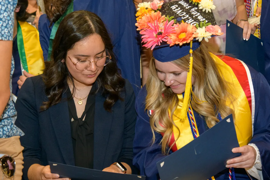 NSCS graduates looking over their diplomas.