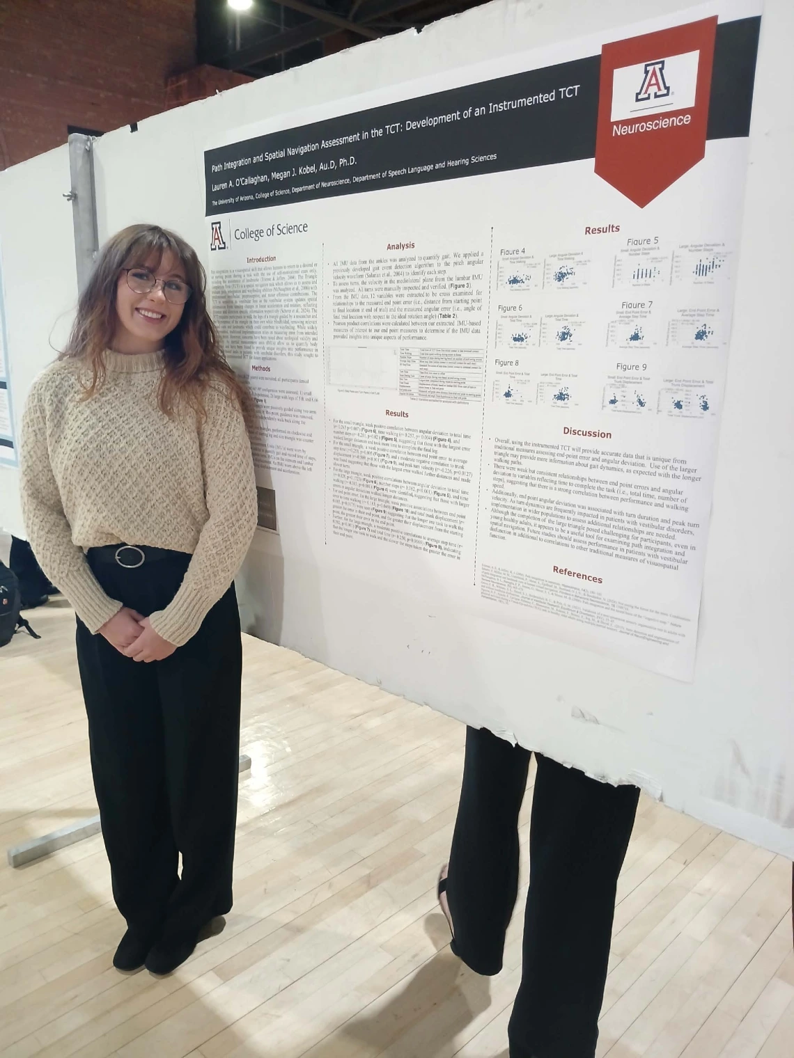 Undergraduate student standing next to their Poster Session Board
