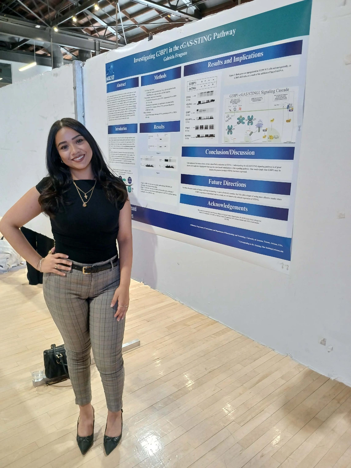 Undergraduate student standing next to their Poster Session Board
