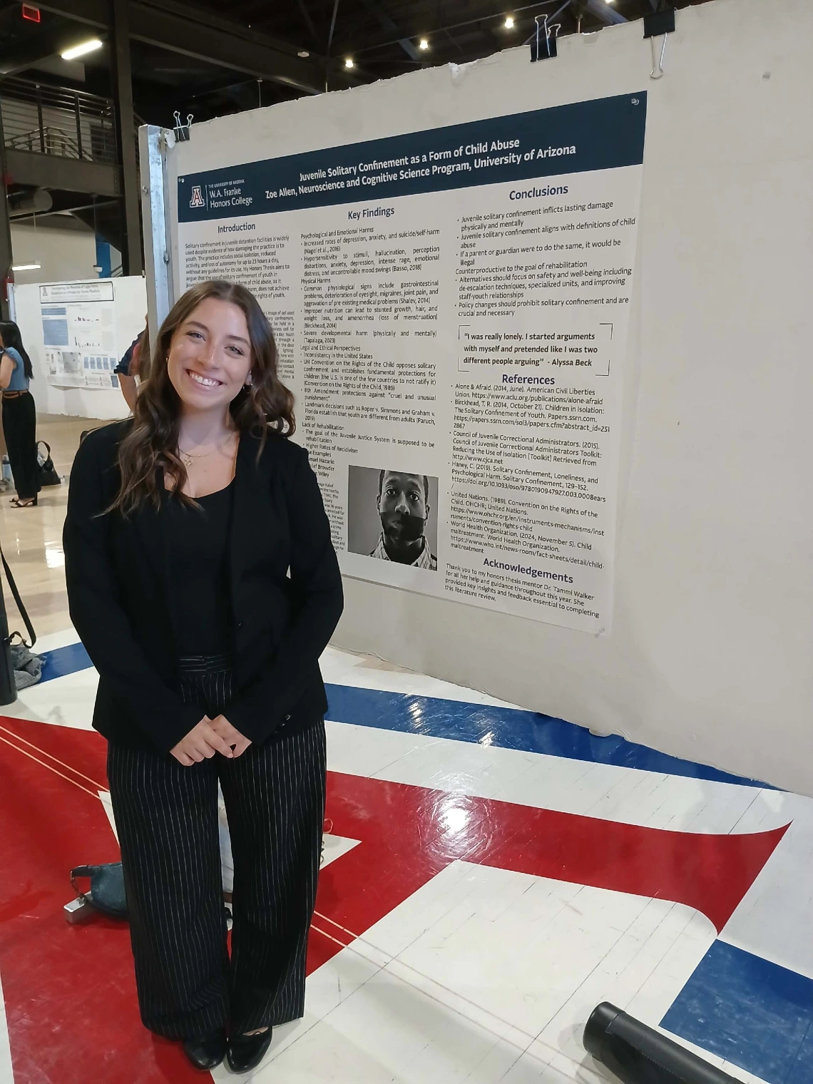Undergraduate student standing next to their Poster Session Board