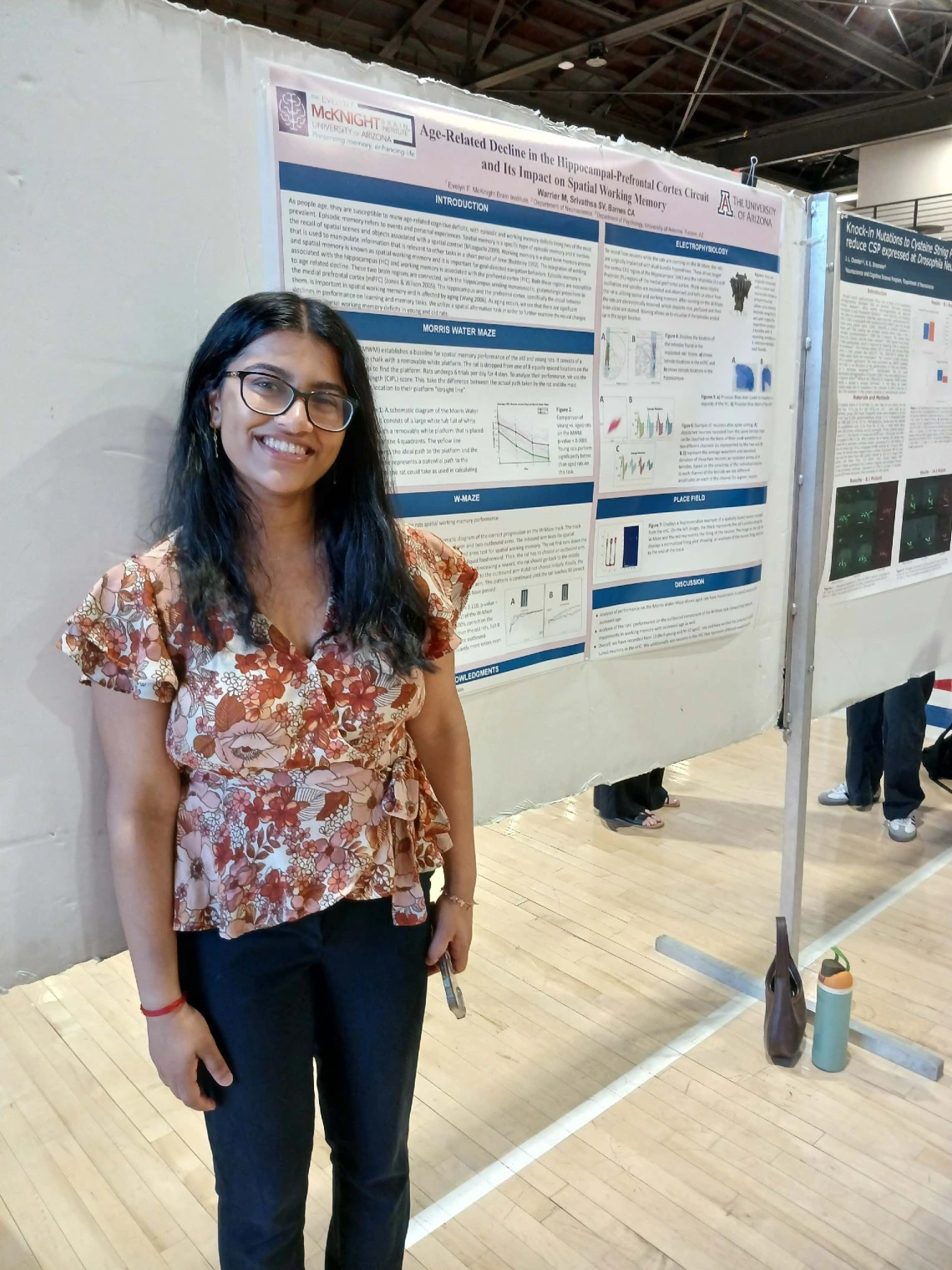 Undergraduate student standing next to their Poster Session Board