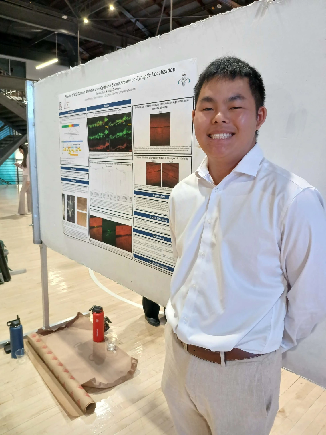 Undergraduate student standing next to their Poster Session Board